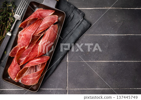 Dry cured and smoked serrano ham, pork meat. black background. top view 137445749