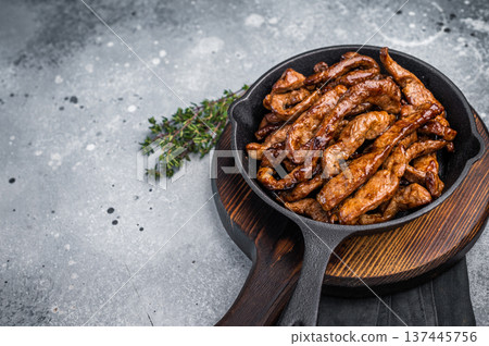 Delicious glazed teriyaki beef in a skillet. grey background. top view Delicious glazed teriyaki beef in a skillet. grey background. top view 137445756