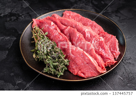 Raw sliced horse meat steaks presented with herbs and spices, inviting creativity in the kitchen for those seeking bold flavors and unique dining experiences. black background. top view Raw sliced horse meat steaks presented with herbs and spices, inviting creativity in the kitchen for those seeking bold flavors and unique dining experiences. black background. top view 137445757