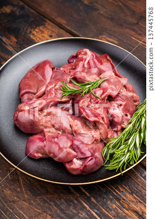 Raw chicken liver, featuring a glossy sheen and rich hue. A versatile ingredient that brings bold flavors to any culinary creation. wooden background. top view 137445768