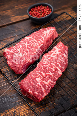 Beef shoulder tender, raw denver steak waiting to be transformed into a gourmet dish. Ideal for grilling or roasting for an unforgettable dinner. wooden background. top view Beef shoulder tender, raw denver steak waiting to be transformed into a gourmet dish. Ideal for grilling or roasting for an unforgettable dinner. wooden background. top view 137445770