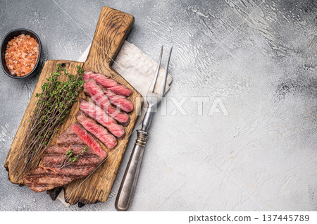 Flavorsome beef Denver shoulder tender, grilled in BBQ to juicy perfection, served with fresh herbs. grey background. top view Flavorsome beef Denver shoulder tender, grilled in BBQ to juicy perfection, served with fresh herbs. grey background. top view 137445789