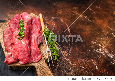 Beautifully arranged raw horse meat slices on a wooden platter, showcasing its appealing color and texture, perfect for cooking inspiration. brown background. top view Beautifully arranged raw horse meat slices on a wooden platter, showcasing its appealing color and texture, perfect for cooking inspiration. brown background. top view 137445806
