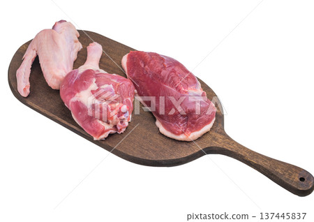 Fresh uncooked duck cuts on rustic wooden board against bright surface perfect for culinary preparation visuals and recipe content. 137445837