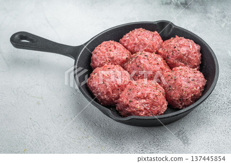 Raw kofta style meatballs seasoned in skillet over rustic board ideal for culinary, kitchen and ingredient stock photography. 137445854