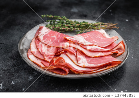 Sliced gammon displayed with pink salt and metal fork on a dark textured backdrop perfect for gourmet food photography. Sliced gammon displayed with pink salt and metal fork on a dark textured backdrop perfect for gourmet food photography. 137445855