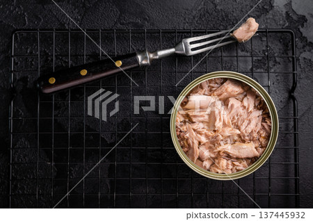 Convenient tinned tuna fillet, perfect for quick meals and packed with protein for a healthy lifestyle. black background. top view 137445932