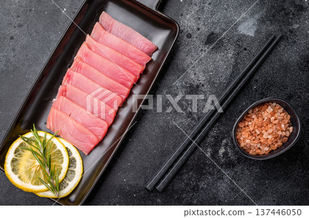 Premium quality tuna sashimi, expertly cut for maximum tenderness and taste, perfect for sushi enthusiasts. black background. top view Premium quality tuna sashimi, expertly cut for maximum tenderness and taste, perfect for sushi enthusiasts. black background. top view 137446050