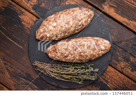 A platter of raw lula kebabs marinated in aromatic herbs, perfect for barbecuing or grilling at your next gathering. wooden background. top view A platter of raw lula kebabs marinated in aromatic herbs, perfect for barbecuing or grilling at your next gathering. wooden background. top view 137446051