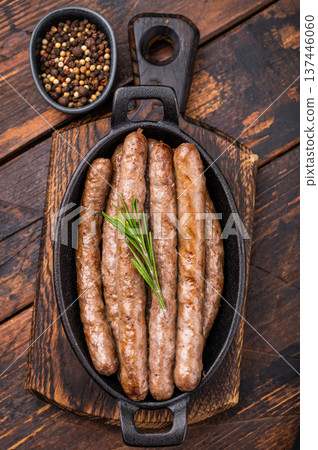 Delicious grilled sausage served with fresh herbs, a mouthwatering addition to any picnic or backyard party. wooden background. top view Delicious grilled sausage served with fresh herbs, a mouthwatering addition to any picnic or backyard party. wooden background. top view 137446060