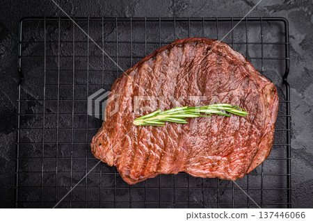A mouthwatering grilled top sirloin or rump beef steak, showcasing beautiful grill marks. black background. top view A mouthwatering grilled top sirloin or rump beef steak, showcasing beautiful grill marks. black background. top view 137446066