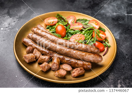 Close up of perfectly charred grilled sausage with salad, ideal for adding flavor to your favorite dishes or sandwiches. black background. top view Close up of perfectly charred grilled sausage with salad, ideal for adding flavor to your favorite dishes or sandwiches. black background. top view 137446067