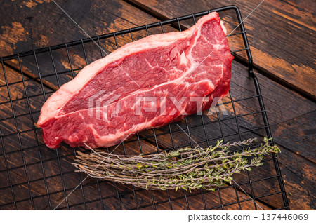 High quality raw striploin steak ready for seasoning, perfect for crafting the ultimate steak dinner experience. wooden background. top view 137446069