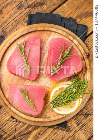 High quality raw tuna steak loin, perfect for a refreshing poke bowl or a delicious seared dish that impresses every time. wooden background. top view High quality raw tuna steak loin, perfect for a refreshing poke bowl or a delicious seared dish that impresses every time. wooden background. top view 137446088
