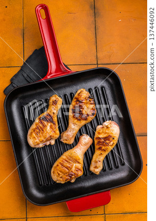 Succulent grilled drumsticks, marinated to perfection and served hot off the grill for a delightful dining experience. orange background. top view 137446092