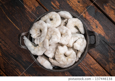 Frozen raw shrimp prawn on a dark rustic wooden background with fresh thyme. High-quality seafood ingredient for healthy gourmet cooking. 137446138