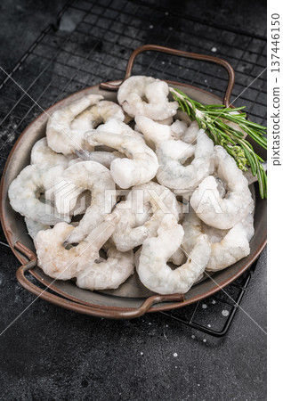 Frozen raw shrimp prawns in a rustic metal bowl with fresh rosemary. Dark and moody food photography for a premium gourmet menu. Frozen raw shrimp prawns in a rustic metal bowl with fresh rosemary. Dark and moody food photography for a premium gourmet menu. 137446150