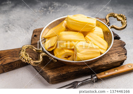 Sweet, golden jackfruit pods (bulbs) in a traditional metal bowl with a fork. Exotic tropical snack or dessert with copy space Sweet, golden jackfruit pods (bulbs) in a traditional metal bowl with a fork. Exotic tropical snack or dessert with copy space 137446166
