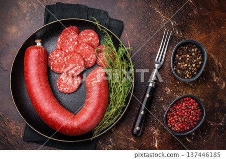 Sliced and whole Turkish sucuk (sujuk) in a cast iron pan with thyme. Spicy dry-cured sausage, top view. Sliced and whole Turkish sucuk (sujuk) in a cast iron pan with thyme. Spicy dry-cured sausage, top view. 137446185