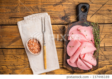 Ready-to-eat pink cold cuts (ham) on a rustic board, set against a black stone or concrete background. Food for a quick snack. Ready-to-eat pink cold cuts (ham) on a rustic board, set against a black stone or concrete background. Food for a quick snack. 137446189