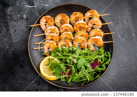 Gourmet seafood appetizer: prawn shrimp kebabs and fresh salad with lemon. Top-down view with vintage fork and copy space. Gourmet seafood appetizer: prawn shrimp kebabs and fresh salad with lemon. Top-down view with vintage fork and copy space. 137446190