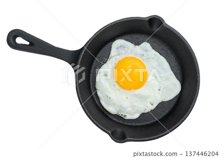 Hot fried egg with bright yolk in cast iron skillet. Crisp edges and clean minimal style perfect for breakfast food themes. 137446204