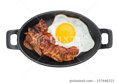 Sizzling bacon beside golden egg in cast iron dish, rich textures and appetizing shine great for breakfast and morning cuisine. Sizzling bacon beside golden egg in cast iron dish, rich textures and appetizing shine great for breakfast and morning cuisine. 137446215