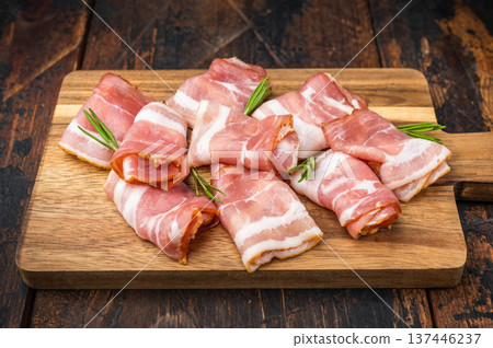 Cured streaky bacon rolls displayed on board with herbs perfect for charcuterie menus culinary visuals and meal prep Cured streaky bacon rolls displayed on board with herbs perfect for charcuterie menus culinary visuals and meal prep 137446237