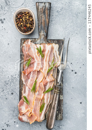 Raw streaky bacon pork slices with rosemary on rustic board perfect for cooking themes recipe visuals and gourmet food Raw streaky bacon pork slices with rosemary on rustic board perfect for cooking themes recipe visuals and gourmet food 137446245