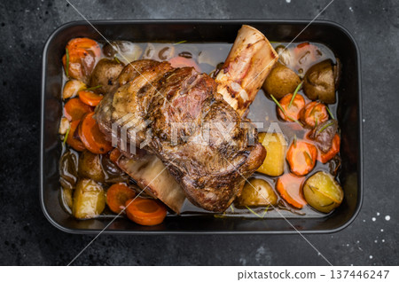 Slow roasted veal shank ossobuco with bone marrow vegetables and rich gravy in baking dish top view 137446247