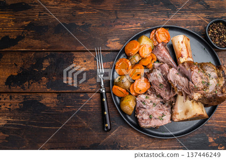 Braised Slow cooked beef osso buco with juicy meat texture marrow bone and roasted vegetables top view 137446249