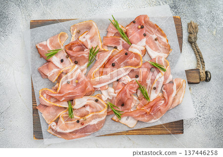 Raw streaky bacon pork slices on parchment with rosemary and peppercorns perfect for cooking themes recipes Raw streaky bacon pork slices on parchment with rosemary and peppercorns perfect for cooking themes recipes 137446258