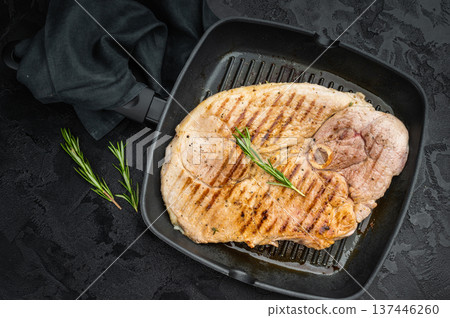 Grilled bone in pork shoulder in grill pan with rosemary on dark textured background juicy cooked meat with grill marks and copy space 137446260