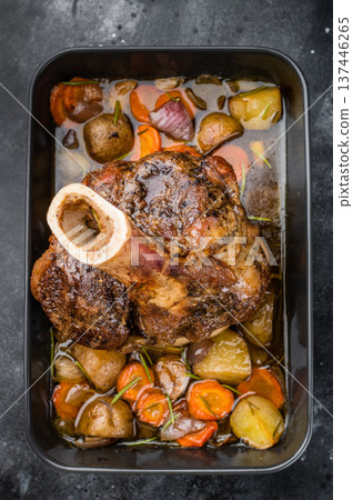 Juicy braised beef shank ossobuco cooked with potatoes carrots herbs and flavorful sauce 137446265