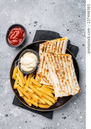 Chicken Fajita wrap sandwich with fresh salad and french fry on a plate. gray background. top view 137446363