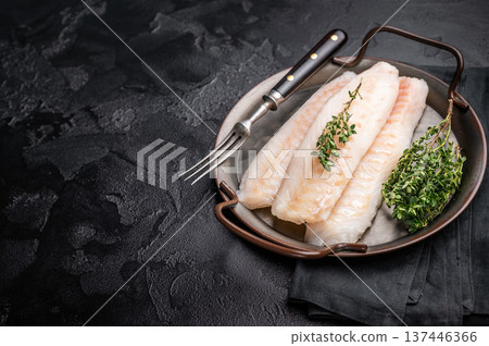 Raw Loin cod fish fillets ready for cooking whitefish in stell tray. black background. top view Raw Loin cod fish fillets ready for cooking whitefish in stell tray. black background. top view 137446366