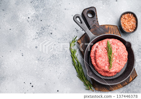 Ready for cooking Raw beef meat patties, cutlets with herbs in pan. grey background. top view 137446378
