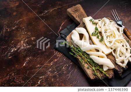 Traditional Caucasian Chechil white cheese on wooden board, brown background. 137446390