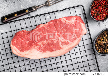 Fresh Raw New York strip beef steak, strip loin with herbs. grey background. top view Fresh Raw New York strip beef steak, strip loin with herbs. grey background. top view 137446436