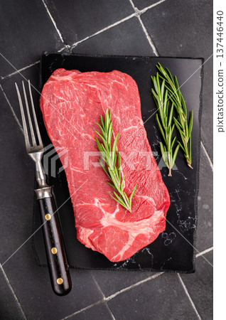 Delicious marbled Raw top sirloin beef steak with rosemary. black background. top view Delicious marbled Raw top sirloin beef steak with rosemary. black background. top view 137446440