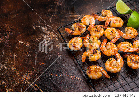 Grilled Shrimps Prawns with garlic on a rack. Brown background. Top view 137446442