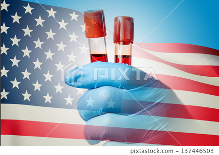 Blue-gloved hand holds test tubes with red liquid 137446503