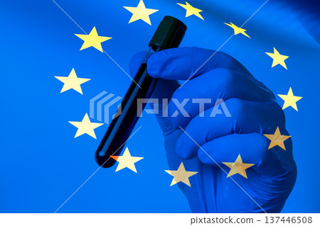 Gloved hand holds test tube against EU flag backdrop Gloved hand holds test tube against EU flag backdrop 137446508