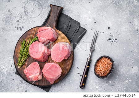 Beautifully cut raw pork medallions for tenderloin meat, waiting to absorb your favorite marinades for a flavorful feast. grey background. top view Beautifully cut raw pork medallions for tenderloin meat, waiting to absorb your favorite marinades for a flavorful feast. grey background. top view 137446514