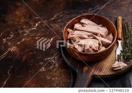 Sustainable tinned tuna fillet in a wooden bowl, promoting eco friendly eating without sacrificing taste. brown background. top view 137446519