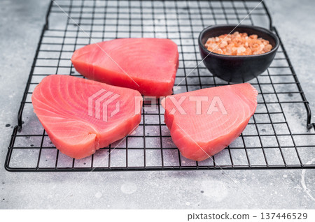 Premium raw tuna fillet steak, ideal for grilling or sashimi, a must-have for gourmet dishes and healthy meals. grey background. top view Premium raw tuna fillet steak, ideal for grilling or sashimi, a must-have for gourmet dishes and healthy meals. grey background. top view 137446529