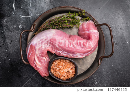 Fresh pork tenderloin fillet, showcasing its lean cut, perfect for marinating and grilling to juicy perfection. black background. top view Fresh pork tenderloin fillet, showcasing its lean cut, perfect for marinating and grilling to juicy perfection. black background. top view 137446535
