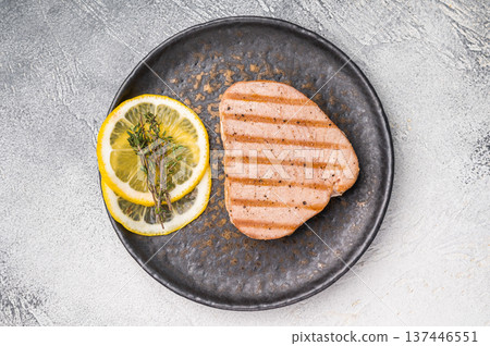Deliciously charred grilled tuna steak, served with fresh herbs, a healthy and flavorful choice for any meal. white background. top view Deliciously charred grilled tuna steak, served with fresh herbs, a healthy and flavorful choice for any meal. white background. top view 137446551