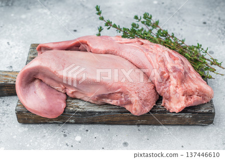 Whole uncooked lamb tongue displayed with herbs spices and vintage fork on light stone background perfect for cuisine prep and food photography 137446610
