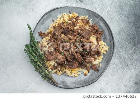 Turkish kavurma over pilaf showing browned fibers, maillard crust, collagen rich shredded meat and detailed macro texture on ceramic plate. Turkish kavurma over pilaf showing browned fibers, maillard crust, collagen rich shredded meat and detailed macro texture on ceramic plate. 137446622
